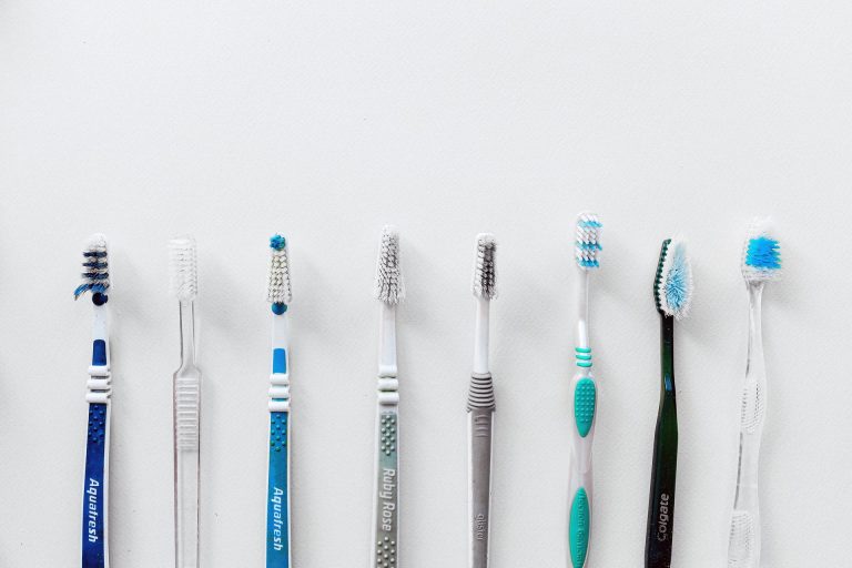 Eight toothbrushes in a line.